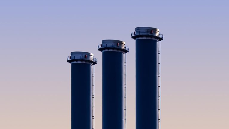 Three blue cylinders are standing in the middle of a field - stock photo